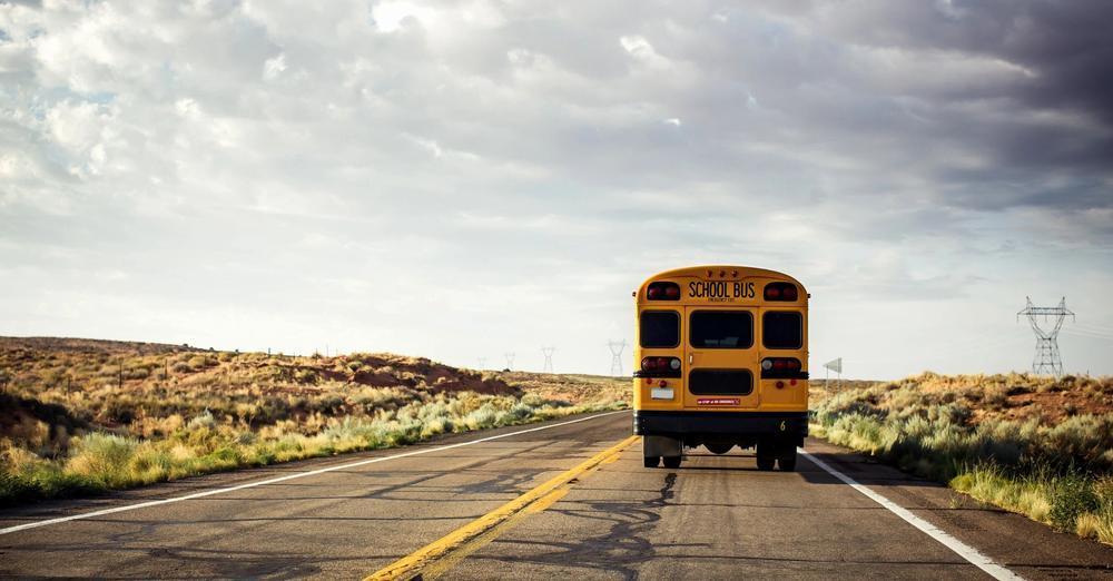 School Bus Driving Away on Road
